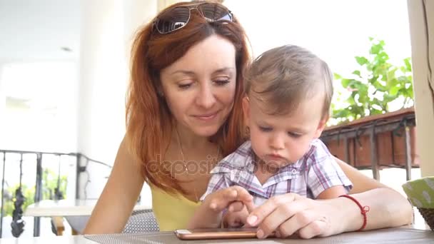 Mom with son use a smartphone for Internet — Stock Video