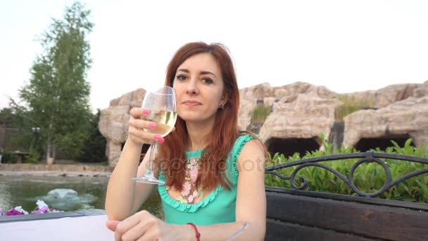 Chica en un restaurante en la calle beber vino — Vídeos de Stock