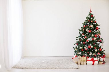 Beyaz odada kırmızı hediyelerle Noel ağacı