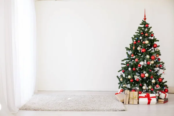 Beyaz odada kırmızı hediyelerle Noel ağacı