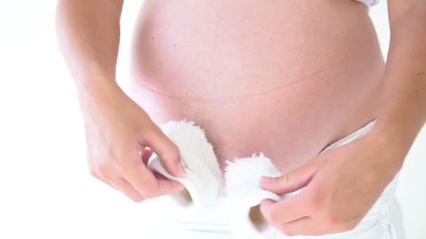 Желудок беременной женщины и детские вещи — стоковое видео