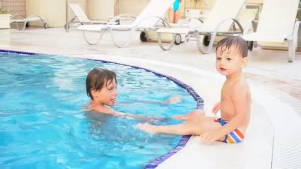Two boys brother bathe in the swimming pool at the resort — Stock Video