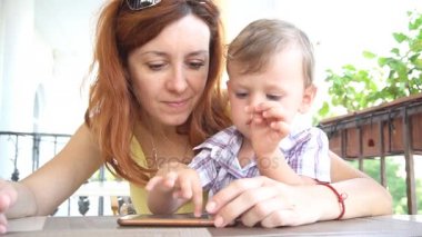 Anne ile küçük bir çocuk Internet Smartphone'da kullanır.