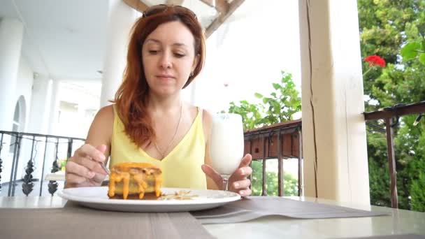 Het meisje met het rode haar is het dessert eten in het restaurant — Stockvideo