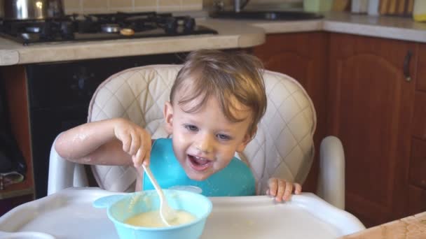 Menino come mingau de cereal para o café da manhã — Vídeo de Stock