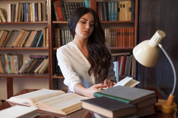 Ragazza seduta a tavola a leggere un libro si sta preparando per l'esame — Foto Stock