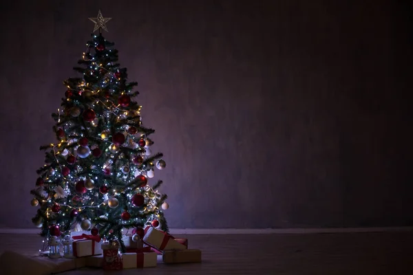 Árbol de Navidad con luces y guirnaldas y regalos a casa para Navidad — Foto de Stock