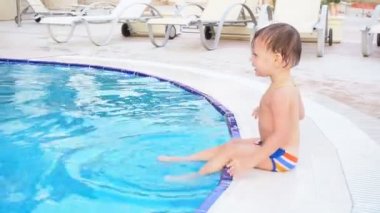 küçük oğlan poolside resort adlı oturuyor