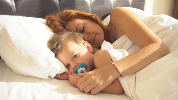 Maman avec son fils bébé se réveilla le matin sur le lit — Video