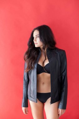 deri ceket ve kırmızı bir arka plan üzerinde siyah iç çamaşırı esmer kız