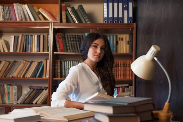 Chica sentada en la mesa leyendo un libro se está preparando para el examen — Foto de Stock