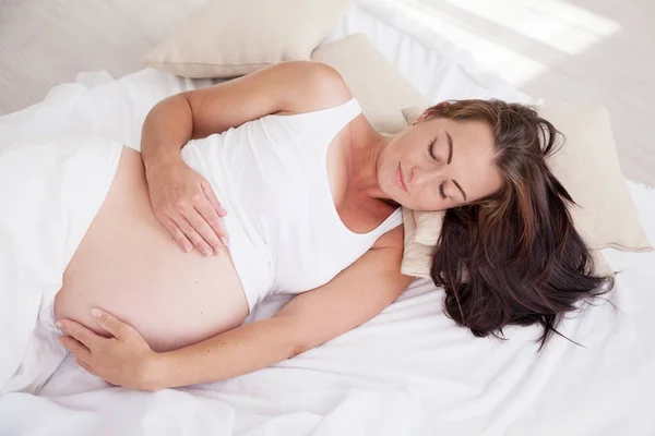 Gravid kvinna som vaknade på morgonen i sängen — Stockfoto