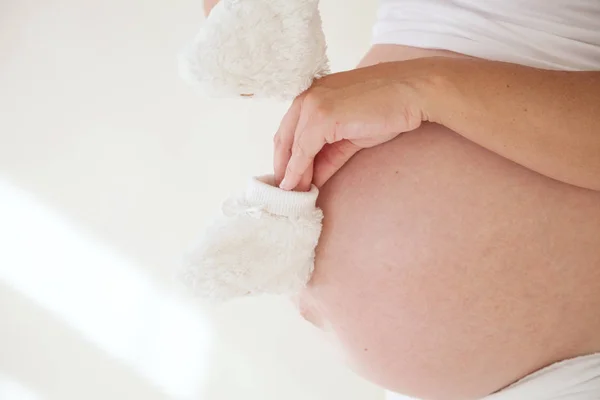 The stomach of a pregnant woman and baby stuff socks 1 — Stock Photo, Image