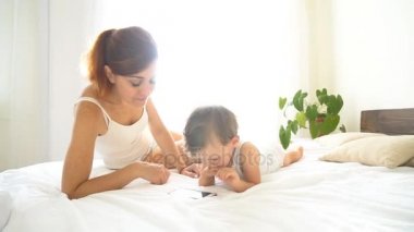 Anne ve bebek yatak odasında smartphone bak