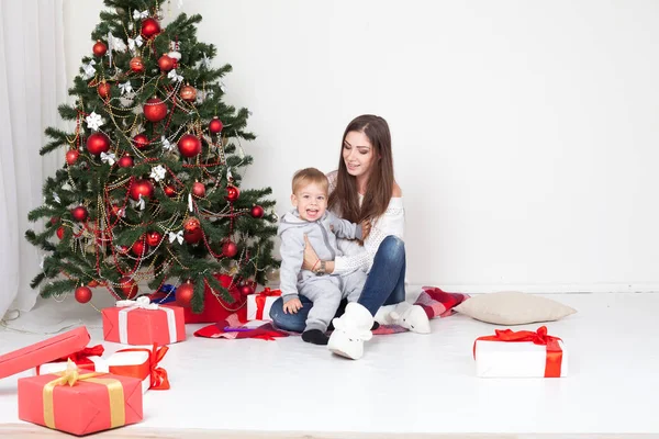 Mamma och pojke på julgran med gåvor 1 — Stockfoto
