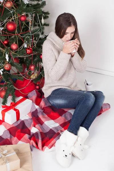 Girl drinking coffee under the Christmas tree new year tea — Stock Photo, Image