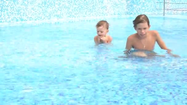 Garçons nageant dans la piscine à la station — Video