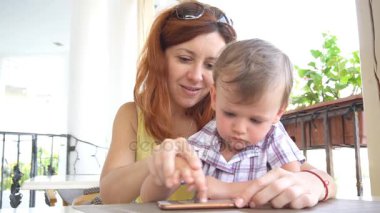 Anne ile küçük bir çocuk Internet Smartphone'da kullanır.
