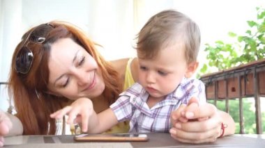Anne ile küçük bir çocuk Internet Smartphone'da kullanır.