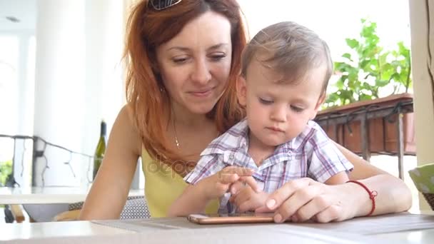 Mom with son use a smartphone for Internet — Stock Video