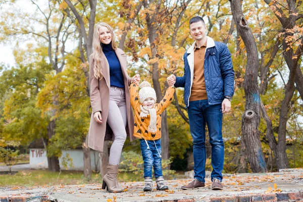 Una familia con un niño en el paseo del bosque de otoño — Foto de Stock