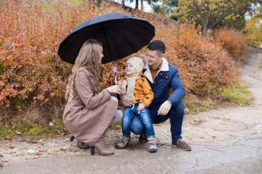 Aile sonbahar yağmur şemsiye parkında