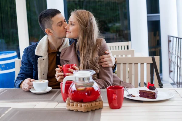 Ресторан на вулиці. хлопець з дівчиною п'є гарячу каву і чай — стокове фото