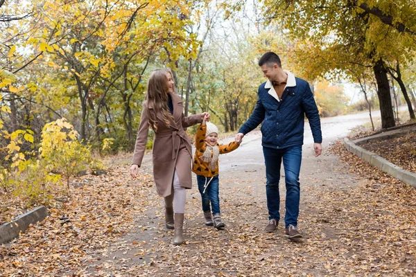 Rodziny z młodym synem spacer w parku jesienią — Zdjęcie stockowe
