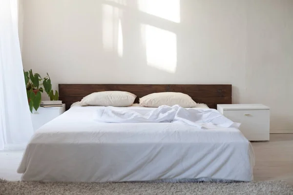 Dormitorio con una cama en una habitación blanca — Foto de Stock