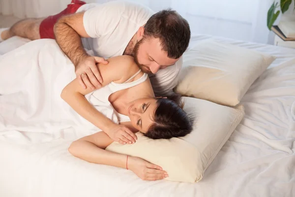 Man wakes a woman in the bedroom in the morning weekend — Stock Photo, Image