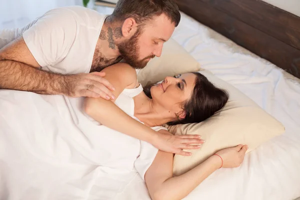 Man wakes a woman in the bedroom in the morning weekend — Stock Photo, Image