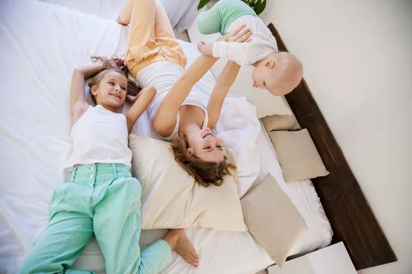 Діти трьох сестер вранці на ліжку в спальні — стокове фото