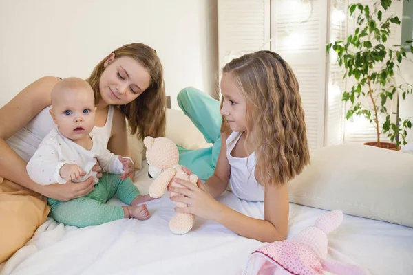 Три сестры новорожденные девочки утром на кровати в спальне — стоковое фото