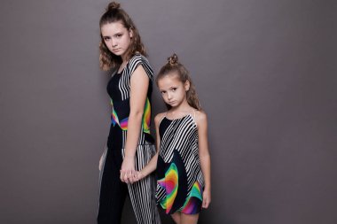 iki kız kardeş gri bir arka plan üzerinde yan yana