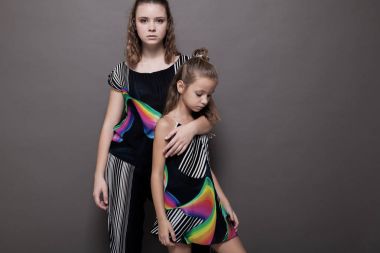 iki kız kardeş gri bir arka plan üzerinde yan yana