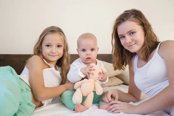 Tres hermanas bebé niña niños por la mañana en la cama en el dormitorio —  Fotos de Stock