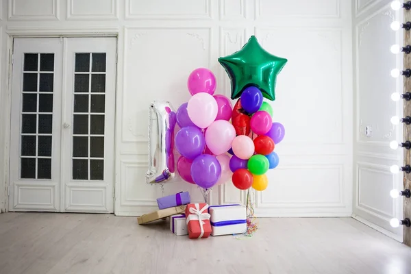 Globos de diferentes colores con regalos para las vacaciones en una habitación —  Fotos de Stock