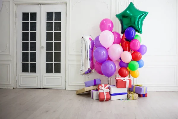 Balões de cores diferentes com presentes para o feriado em um quarto — Fotografia de Stock