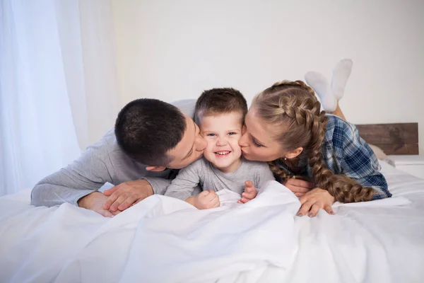 Mom dad and son in the morning lying on the bed at home in a good mood — Stock Photo, Image