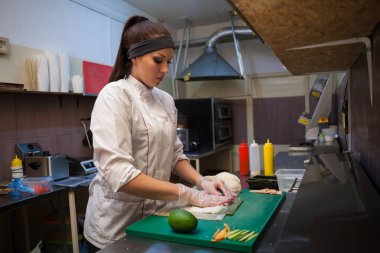 Kız sushi chef restoranda mutfakta yiyecek hazırlar