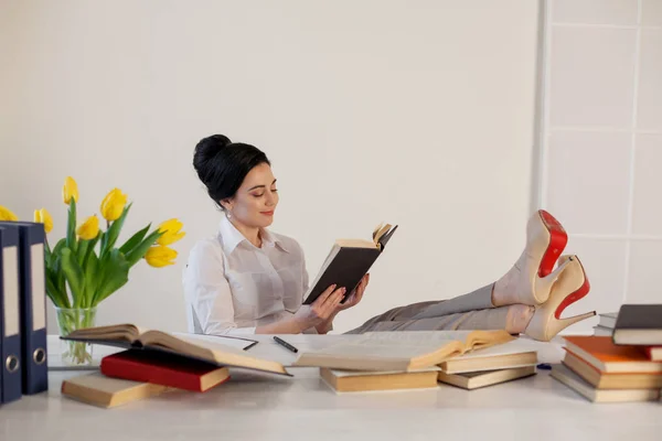 Güzel kız sınava hazırlanıyor masasında kitap okur — Stok fotoğraf