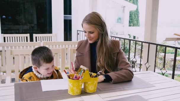 Mother and young son are drawing at a table — Stock Video