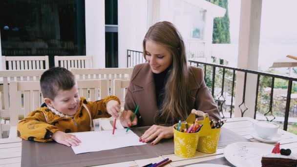 Moeder en zoon aan het tekenen bent aan een tafel — Stockvideo