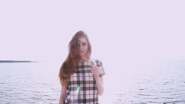 Portrait de belle femme sur la plage par le vent de l'océan souffle — Video