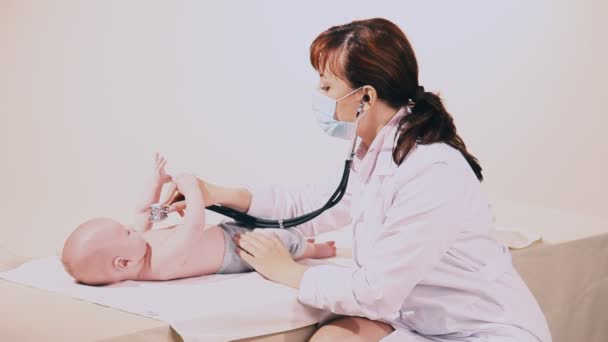 Žena lékař zkoumá kojenecká stetoskop — Stock video