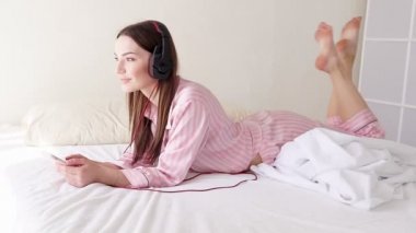 Kadın telefonu yalan ile büyük kulaklıklar müzik dinlemek