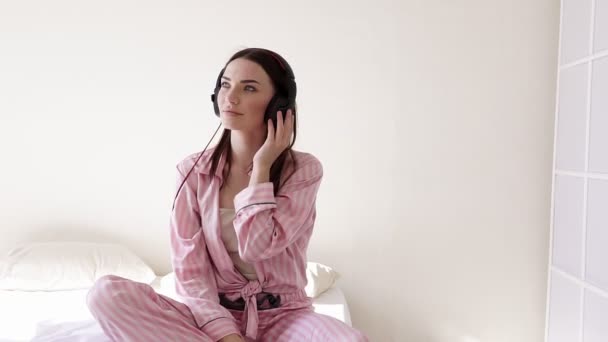 穿睡衣的妇女跳舞从耳机音乐 — 图库视频影像