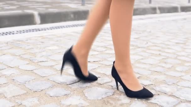 Womens benen in zwarte schoenen op een stenen weg — Stockvideo