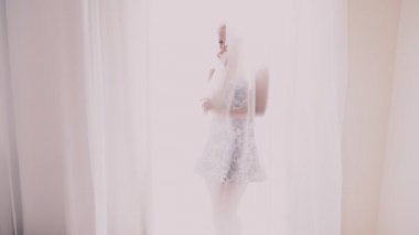 çiçekli elbiseli kız pencerenin önünde duruyor