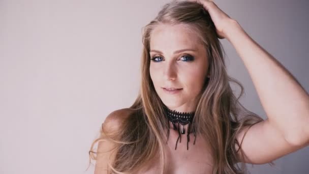 Retrato de una hermosa chica rubia posando sobre un fondo blanco — Vídeos de Stock